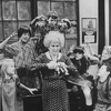 Actress Alice Ghostley surrounded by taunting orphans in a scene from the Broadway production of the musical "Annie.".