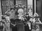 Actress Alice Ghostley surrounded by taunting orphans in a scene from the Broadway production of the musical "Annie.".