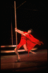 Actress Liza Minnelli swinging on a pole in a red outfit designed by Halston in a scene from the Broadway production of the musical "The Act."