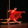 Actress Liza Minnelli swinging on a pole in a red outfit designed by Halston in a scene from the Broadway production of the musical "The Act."