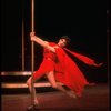 Actress Liza Minnelli swinging on a pole in a red outfit designed by Halston in a scene from the Broadway production of the musical "The Act."