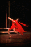 Actress Liza Minnelli swinging on a pole in a red outfit designed by Halston in a scene from the Broadway production of the musical "The Act."
