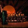 Actress Liza Minnelli in green sequin dress w. dancers seated in a row behind her in a scene from the Broadway production of the musical "The Act." (New York)