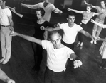 Choreographer Jerome Robbins, in white t-shirt directing male and female chorus members during a rehearsal of "West Side Story".