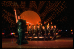 Actress Liza Minnelli in green sequin dress w. dancers seated in a row behind her in a scene from the Broadway production of the musical "The Act." (New York)