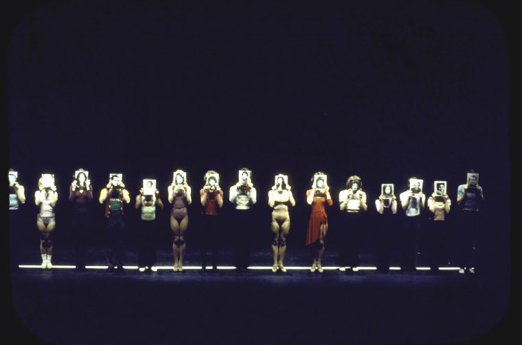Dancers holding their resume photos in front of their faces while performing "I Hope I Get It" in a scene from the Broadway musical "A Chorus Line."