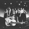 Composer Elizabeth Swados playing guitar with the cast in a scene from the off-Broadway production of the musical "Nightclub Cantata"