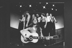 Composer Elizabeth Swados playing guitar with the cast in a scene from the off-Broadway production of the musical "Nightclub Cantata"