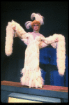George Hearn in drag in a white costume w. a feather boa in a scene from the Broadway musical "La Cage Aux Folles." (New York)