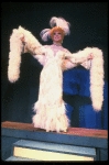 George Hearn in drag in a white costume w. a feather boa in a scene from the Broadway musical "La Cage Aux Folles." (New York)