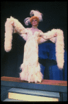 George Hearn in drag in a white costume w. a feather boa in a scene from the Broadway musical "La Cage Aux Folles." (New York)