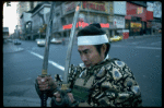 A castmember from the Broadway production of the musical "Pacific Overtures" posing in the middle of Times Square to advertise the show. (New York)