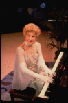 Entertainer the "Incomparable" Hildegarde at the piano in a scene fr. the concert "Big Broadcast of 1944." (Westbury)