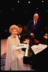 Entertainer the "Incomparable" Hildegarde at the piano & announcer Don Wilson (R) in a scene fr. the concert "Big Broadcast of 1944." (Westbury)