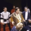 Actor Denzel Washington (C, on table) with cast members in a scene from the New York Shakespeare Festival production of the play "Richard III" at the Delacorte Theatre in Central Park (New York)