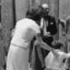 The Kennedy children visit backstage after a New York City Ballet performance of "Nutcracker", Jacqueline Kennedy encourages  young John to shake hands with Shaun O'Brien who played Herr Drosselmeyer, George Balanchine in rear.