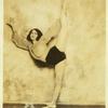 Dancer in practice costume, holding leg in high extension