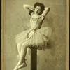 Dancer posed sitting upon a high post