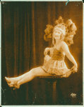 Female dancer sitting on a pillar