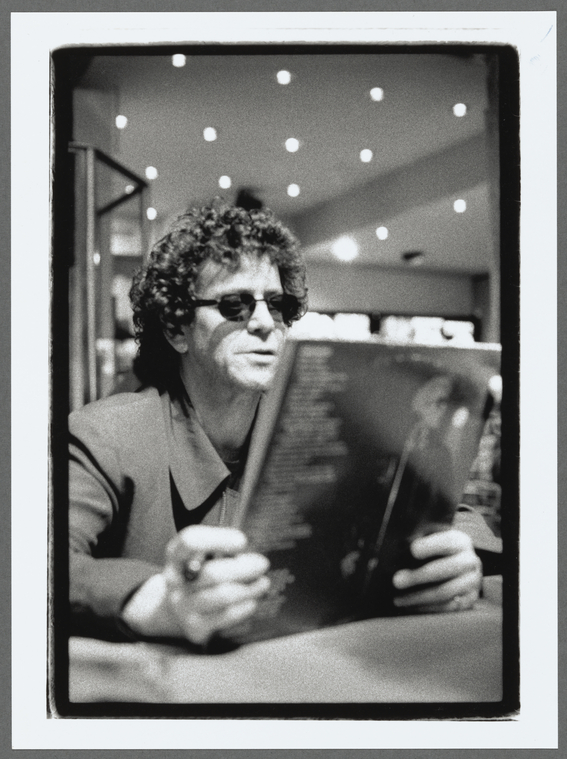 Lou Reed at a signing looking at a copy of Metal Machine Music
